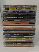 Stack of 15 music CDs from various artists showing album titles and condition