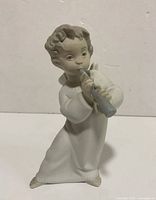 Full figure view of Lladro porcelain angel playing flute figurine showing posture, robe, and flute.