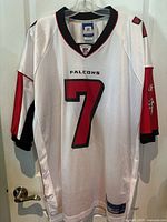 Front view of white Michael Vick Atlanta Falcons football jersey with number 7 and team logos on sleeves.