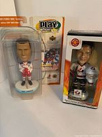 Eric Lindros (left) and Curtis Joseph (right) NHL collectible figures in original packaging, shown front view.