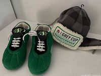 Green Saskatchewan Roughriders slippers and grey winter hat shown together