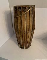 Side view of the handmade Mridangam drum showing vertical tension ropes and wooden body