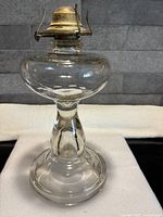 Full view of clear glass oil lamp