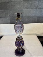 Full view of blown glass perfume bottle showing shape, color, stopper, etched design and applicator