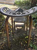 Front view of cast iron tractor seat stool with folding step stool beneath