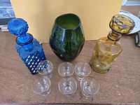 All items group shot: six cordial glasses, blue decanter, amber decanter, green pinch vase