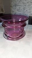 Full side view of mauve art glass vase showing flared rim and rounded base.