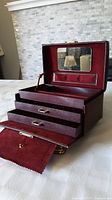 Open view of the jewellery box showing the velvet-lined interior, mirror on the lid, open compartment on top, and two pull-out drawers.