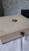 Closed view of the cream velvet vintage jewellery box showing overall condition and closure.