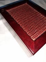 Photo of the closed box showing the varnished wood frame and woven wicker panel on the lid.