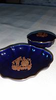 Photo of vintage Limoges cobalt blue porcelain bowl and trinket box with gold-colored decorative figures and scalloped edges