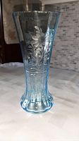 Full view of the blue glass vase showing its shape and etched floral design.