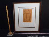 Framed etching next to ruler for scale