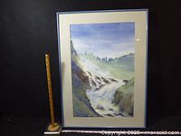 Full view of framed watercolor with ruler and tape for scale