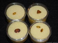 Four plastic gem jars top view showing gemstones