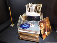 Stack and box of 45 rpm records with some LP covers visible