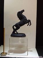 Front left perspective of metal rearing horse on display stand