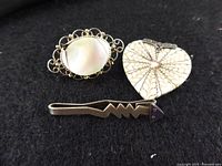 All three sterling silver pieces displayed on black cloth