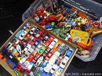 overview of tray with diecast vehicles and tote with mixed toys