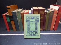 Front view of about 14 vintage hardcover books standing, Macbeth displayed in front, showing various colors and spine titles