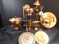 Group shot of all ten copper items including cookware, serveware, lamp, plaques and vase