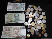 Overall view of three banknotes and pile of assorted coins