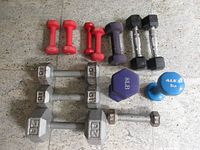 All thirteen dumbbells arranged by size and colour