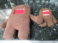 Front view of both Domo plush toys showing facial details and relative sizes
