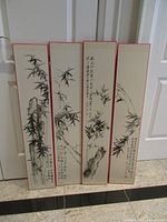 All four vertical bamboo art panels leaned against doors
