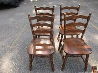 Four wooden ladder-back chairs front view