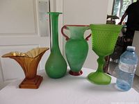 All four vases side by side with water bottle for scale