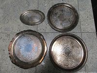 Group view of four silver trays showing overall styles and tarnish
