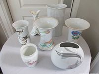 Front view showing all seven porcelain vases on table