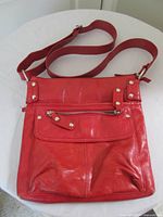 Front view with strap, front pocket and zipper detail visible