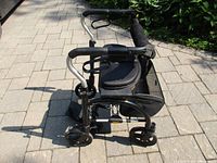 Side view of foldable rollator showing frame, seat, wheels and brakes