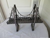 Front view of metal suspension bridge sculpture