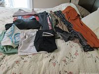Assortment of gym clothes laid on bed