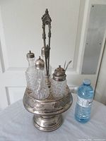 Full view of silver-plated stand and five bottles beside scale bottle