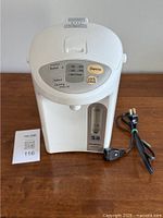 Front view of Panasonic thermo pot showing control panel with buttons and water level indicator with 3L capacity.