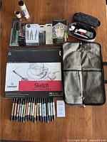 Overview showing sketch pad, marker pens, pencil case, brush bag, and drawing tools laid out