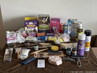 Overview photo showing entire lot of industrial art supplies and sculpting materials laid out on brown cloth surface