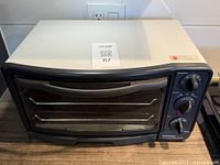 Front view of lightly used Betty Crocker toaster oven showing curved handle, glass door, and control panel with 3 dials