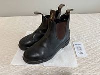 Top side view of the pair of black leather Blundstone Chelsea boots showing elastic side panels and rear pull tabs with logo.