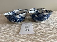 Four Chinese porcelain bowls with blue dragon patterns, shown at side angle to highlight shape and design details, in like new condition.