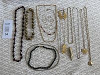Overview of all costume jewelry items laid out showing various necklaces and matching sets with botanical leaf designs and beaded necklaces.