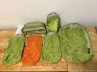 Full set of Eagle Creek Eagle Ridge Pack-It System cubes and toiletry bag displayed on wooden surface.