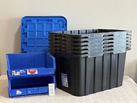 Mastercraft heavy-duty storage box with two blue plastic open bins arranged beside it, showing stackable and sturdy design.