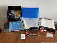 Overview showing binders, folders, stapler, staple remover, scissors, hole punch, tape dispenser, and other office supplies.
