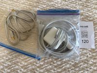 Overview photo showing two cables: Apple magnetic power cable with power adapter in a plastic bag, and a USB printer cable outside the bag.