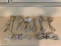 All cords, power bar and wall adapter arranged on surface
